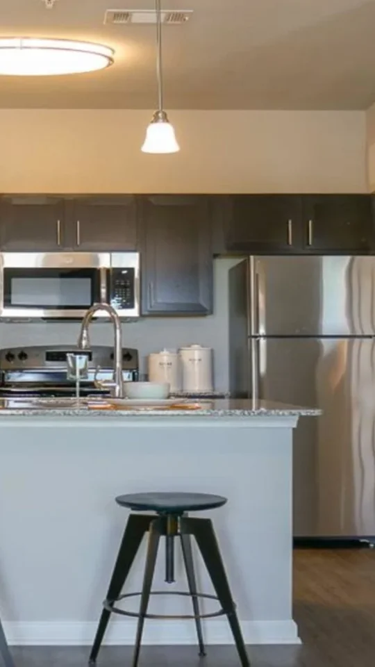 a kitchen with a large island and bar stools at The Biltmore at  Park