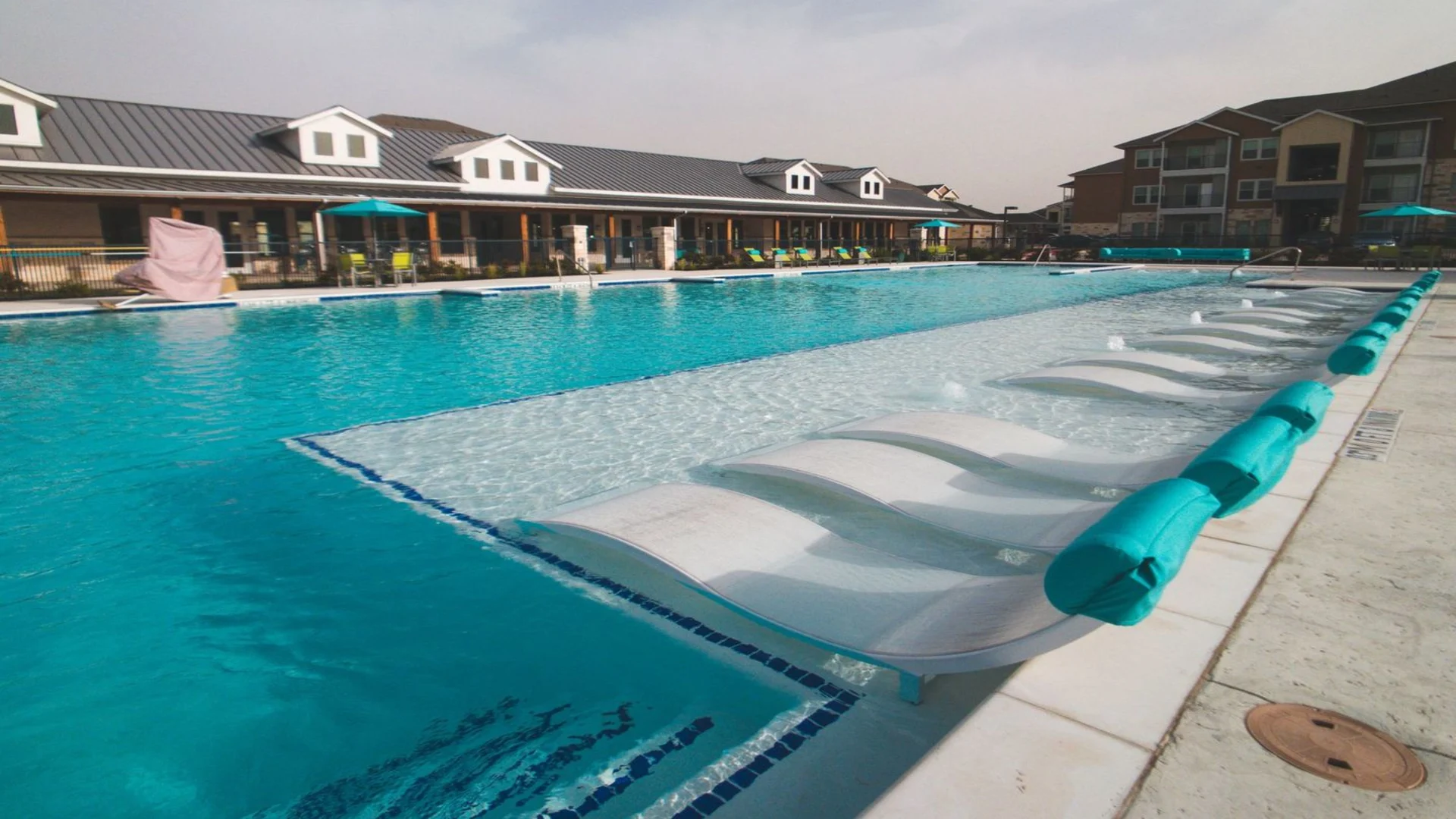 a large pool with lounge chairs and umbrellas at The Biltmore at  Park